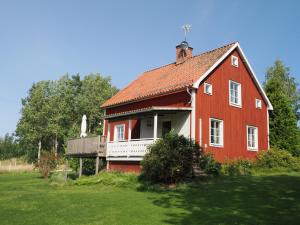 a red house with a porch and a balcony at Semesterhus Dalälven in Sala