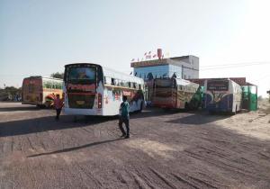 a group of buses parked in a dirt field at Hotel New Kesar Palace in Agolai