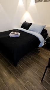 a bedroom with a black bed with a wooden floor at Cozy studio near by the beach - Intercontinental in Hurghada