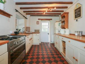 a kitchen with white cabinets and a checkered floor at Melin Rhos Farm in Penrhos-Lligwy +32 photos