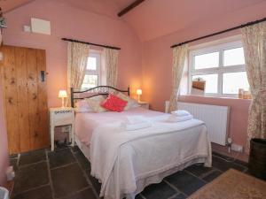 a bedroom with a bed with two towels on it at Melin Rhos Farm in Penrhos-Lligwy
