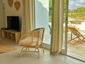 a chair in a living room with a sliding glass door at Casa Verde Oliva Alentejo in Alandroal