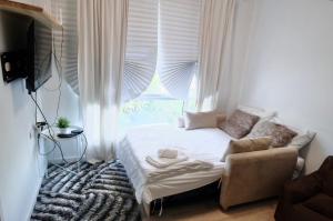 a small bedroom with a bed and a window at 7min BKK airport - free pick up - malls nearby in Bangkok