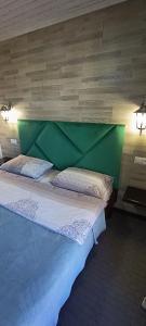 a large bed with a green headboard in a room at Садиба Янчар Номер Студiо з Басейном in Mykulychyn +33 photos