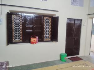 a room with two wooden doors and a window at SHRI NIWAS GUEST HOUSe in Jaipur