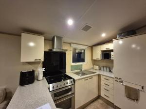 a small kitchen with a stove and a refrigerator at Sapphire in Saint Leonards