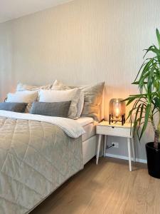 a bedroom with a bed and a table with a plant at Stylish & Central by the pier Cozy balcony in Arendal +26 photos