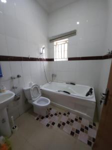 a bathroom with a tub and a toilet and a sink at Smart 1 bedroom by Stella Maris Life camp, Abuja in Gwarinpa