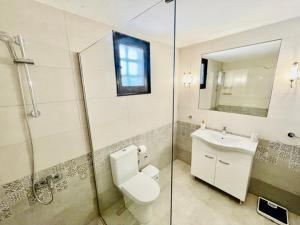 ein Badezimmer mit Toilette, Waschbecken und Spiegel in der Unterkunft Villa Pharaoh Private Pool Near the Beach in Porto Rafti + 19 Fotos