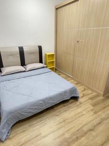 a bedroom with a bed and a wooden floor at Hann's Residence - Anna 温馨公寓式的住宅 in Sibu
