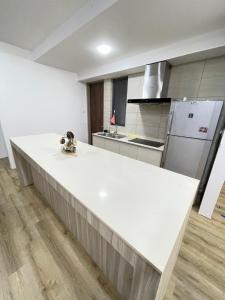 a white kitchen with a large white counter top at Hann's Residence - Anna 温馨公寓式的住宅 in Sibu