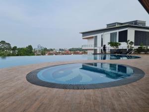 a person standing next to a swimming pool in a house at Hann's Residence - Anna 温馨公寓式的住宅 in Sibu