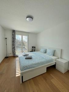 una camera da letto con un letto e una finestra di VK - HL - Zürich Airport - Luxury - Homestay - Härdlenstrasse - Kloten a Kloten