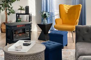a living room with blue and orange chairs and a fireplace at The Hub in Fayetteville