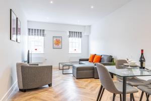 een woonkamer met een bank en een tafel bij Wellington House by Celador Apartments in Reading