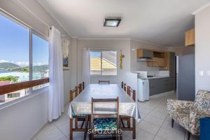 a kitchen and dining room with a table and chairs at Apto Vista Mar 3Q e Garagem 130m da Praia ROR0002 in Bombas