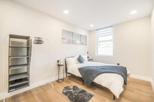 a white bedroom with a bed and a book shelf at Royal Docks Cozy Studio Flat C in London