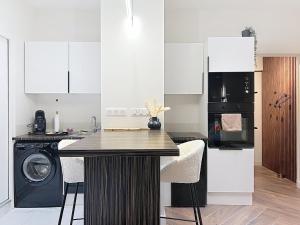 a kitchen with a counter and a washer and dryer at V' Appart SPA Moderne-Chic in Troyes +14 photos