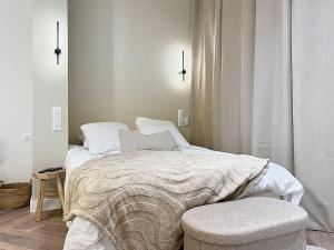 a white bedroom with a bed and a chair at V' Appart SPA Moderne-Chic in Troyes