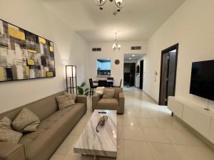 a living room with a couch and a tv at Silicon Heights II in Dubai