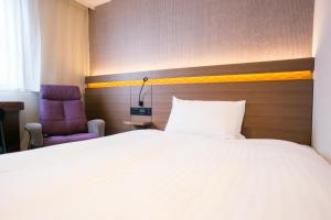 Postel nebo postele na pokoji v ubytování Nishitetsu Hotel Croom Hakata
