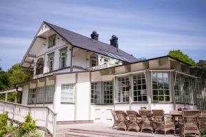 a large white house with chairs in front of it at Villa Strandvägen in Ystad