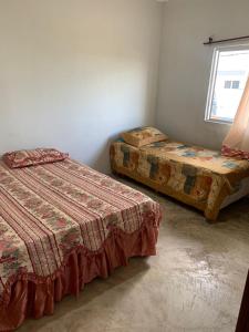 una habitación con dos camas y una ventana en Por do Sol Em Guriri, en São Mateus