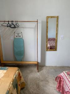 Habitación con una tabla de surf en la pared y un espejo. en Por do Sol Em Guriri, en São Mateus 2 fotos más