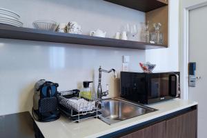 a kitchen counter with a sink and a microwave at Aparthotel AMMI Vieux Nice in Nice