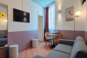 a living room with a couch and a table at Aparthotel AMMI Vieux Nice in Nice