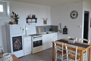 a kitchen with white appliances and a wooden table at Petit Paris in Kergrist