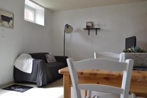 een woonkamer met een bank, een tafel en stoelen bij Petit Paris in Kergrist +2 foto's