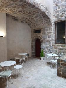 a patio with tables and chairs and a brick wall at Auberge La Tournelle in Saint-Jean-de-Valériscle