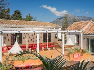 a patio with red couches and a white pergola at Boho Club in Marbella