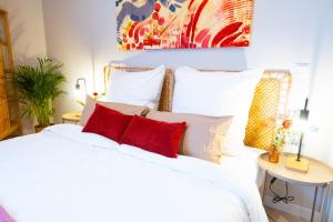 ein Schlafzimmer mit einem weißen Bett mit roten Kissen in der Unterkunft BetterBeds Essen in Essen