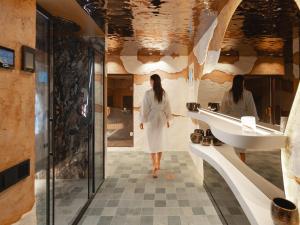 a woman walking in a bathroom with a sink at Boho Club in Marbella