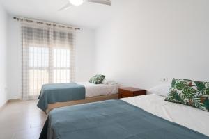 a bedroom with two beds and a window at Chalet - Montes de Oca in El Puerto de Santa María