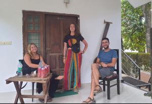 a group of three people standing on a porch at ABRU'S Holidays International Travelers in Alleppey