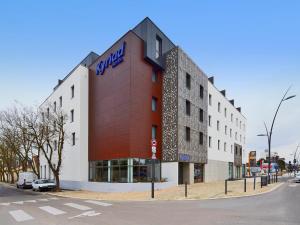 un bâtiment avec un panneau sur son côté dans l'établissement Kyriad Troyes Centre, à Troyes