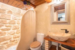 Un baño con lavabo y pared de piedra. en La Casuca, en Olba 13 fotos más