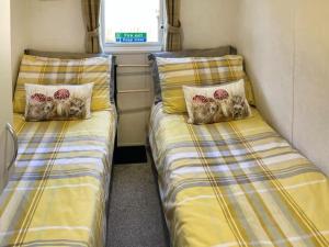 two twin beds in a small room with at Holiday Home by the river Nidd 4 in Knaresborough