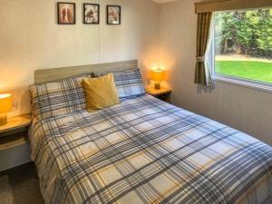 a bedroom with a bed with two lamps and a window at Holiday Home by the river Nidd 4 in Knaresborough