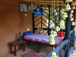 a room with a bed and a table and lamps at Camp Hornbill Corbett in Rāmnagar