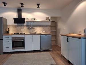 a kitchen with white cabinets and a sink at Apartmani Alma in Pula