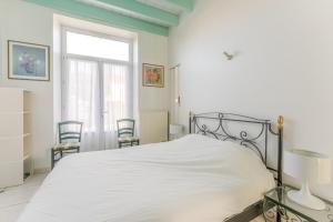 een slaapkamer met een bed en een raam en stoelen bij L'Embrun - T5 - Wifi - Accès à la mer in La Bernerie-en-Retz