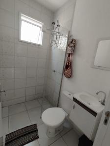 a white bathroom with a toilet and a sink at Casa de férias Pôr do Sol in Presidente Epitácio +35 photos
