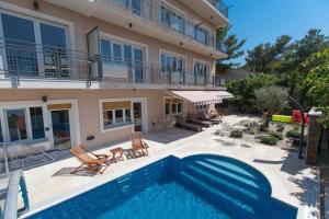a house with a swimming pool next to a building at Anikol Apartments in Selce