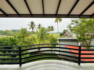 a bench on a balcony with palm trees in the background at Green field Inn in Wellawatta