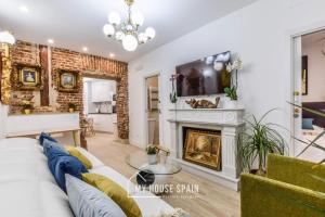 salon z białą kanapą i kominkiem w obiekcie MyHouseSpain - Sensacional piso en Malasaña w Madrycie