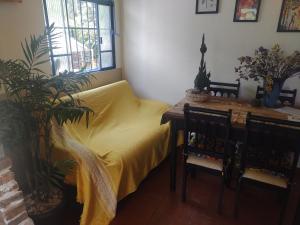 a bedroom with a yellow bed and a table and chairs at Casinha próxima a Praça Tiradentes in Ouro Preto